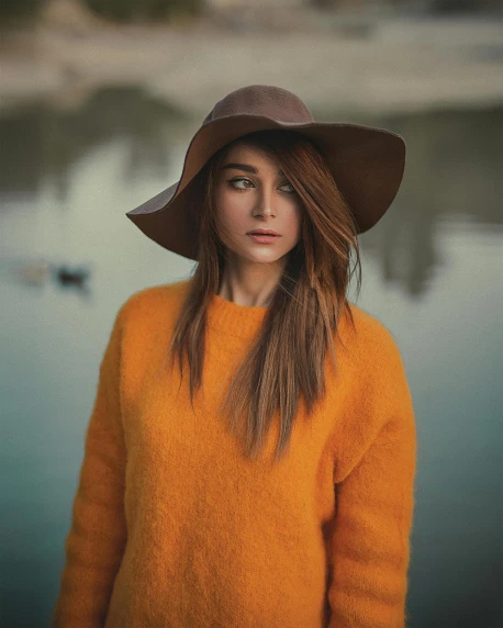 a woman in an orange sweater and a brown hat, inspired by Oleg Oprisco, trending on pexels, casual pose, desaturated, dark gold hair, attractive brown hair woman