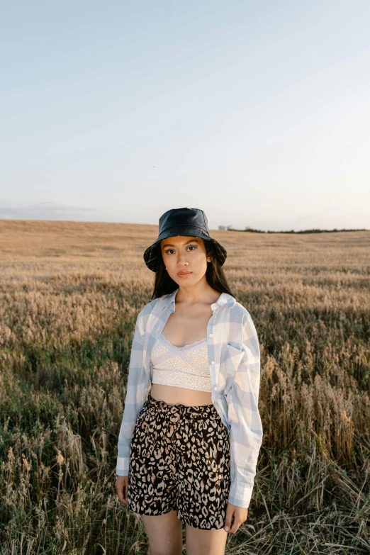 a woman standing in a field wearing a hat, an album cover, trending on pexels, croptop, portrait sophie mudd, asian woman, high quality photo