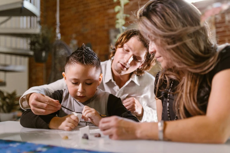 a woman and two children sitting at a table, pexels contest winner, interactive art, engineer, over his shoulder, jewelry, lachlan bailey