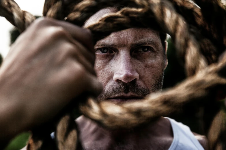 a close up of a person holding a rope, a portrait, by Giuseppe Avanzi, pexels contest winner, jason statham, caramel. rugged, instagram picture, 38 years old