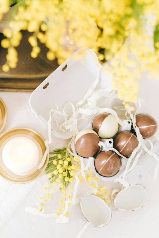 a bunch of eggs sitting on top of a table, white candles, chocolate, white and yellow scheme, detailed product shot