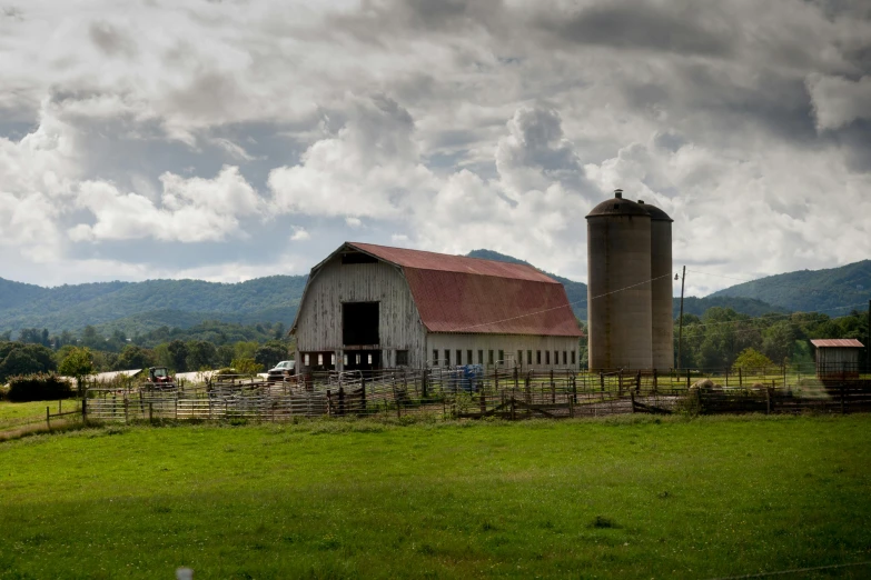 a barn sitting on top of a lush green field, by Neil Blevins, pexels contest winner, overcast gray skies, panoramic, alabama, from street level