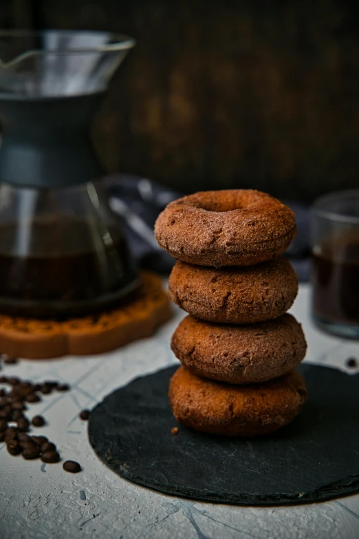 three chocolate donuts stacked on top of each other, a portrait, by Julia Pishtar, pexels contest winner, portrait of morning coffee, volcanic, brown:-2, dark angel of coffee