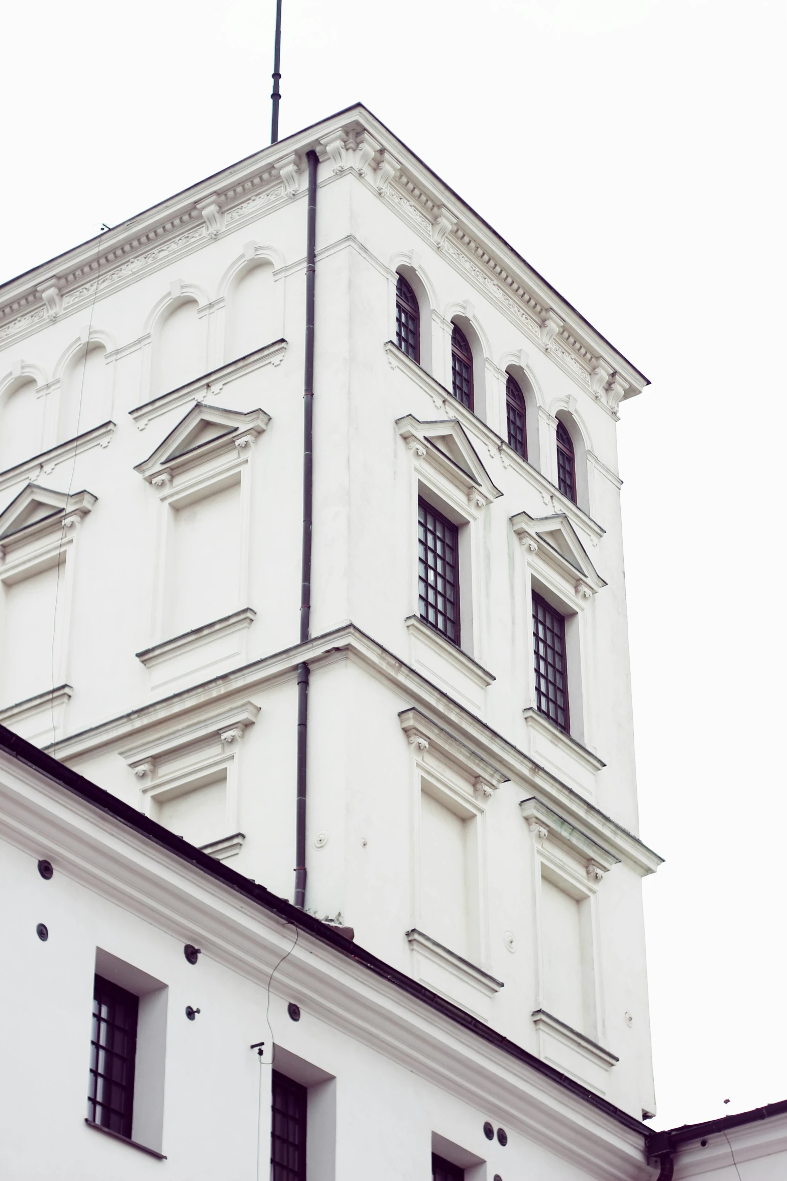 a tall white building with a clock on top of it, inspired by Mihály Munkácsy, trending on unsplash, neoclassicism, tallinn, church, low quality photo, white wall