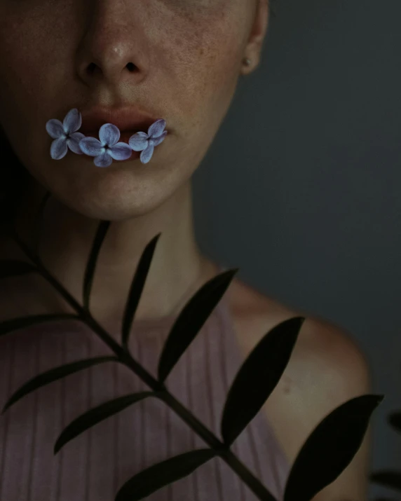 a woman with a flower in her mouth, inspired by Elsa Bleda, unsplash contest winner, aestheticism, blue - petals, non binary model, ilustration, low quality photo