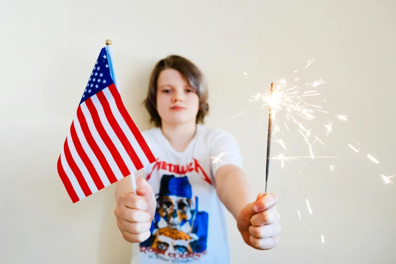 a girl holding a sparkler and an american flag, an album cover, pexels, visual art, declan mckenna, children's, decoration, holding a trident