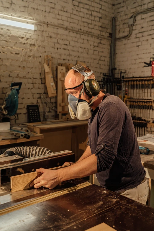 a man using a table saw to cut a piece of wood, an album cover, arbeitsrat für kunst, wearing facemask, profile image, rik oostenbroek, foundry vtt