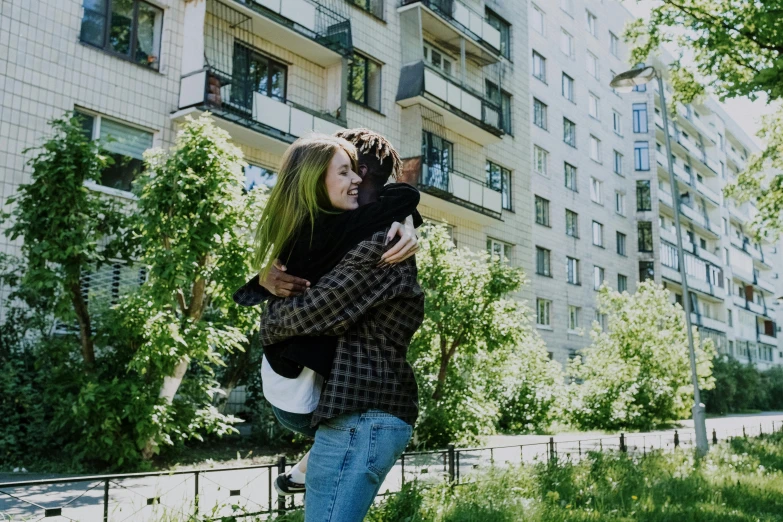 a woman holding a black cat in her arms, by Emma Andijewska, unsplash, graffiti, soviet apartment buildings, two men hugging, 😭 🤮 💕 🎀, anya_taylor-joy