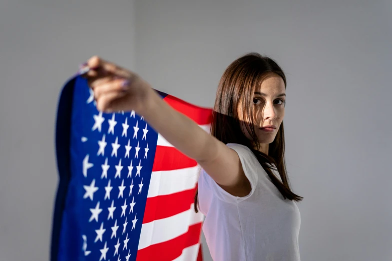 a woman holding an american flag in front of her face, pexels contest winner, confident action pose, pokimane, avatar image, battle pose