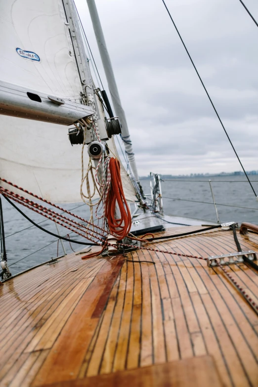 a close up of a sail boat on a body of water, on a cloudy day, cockpit view, wooden sailboats, seattle
