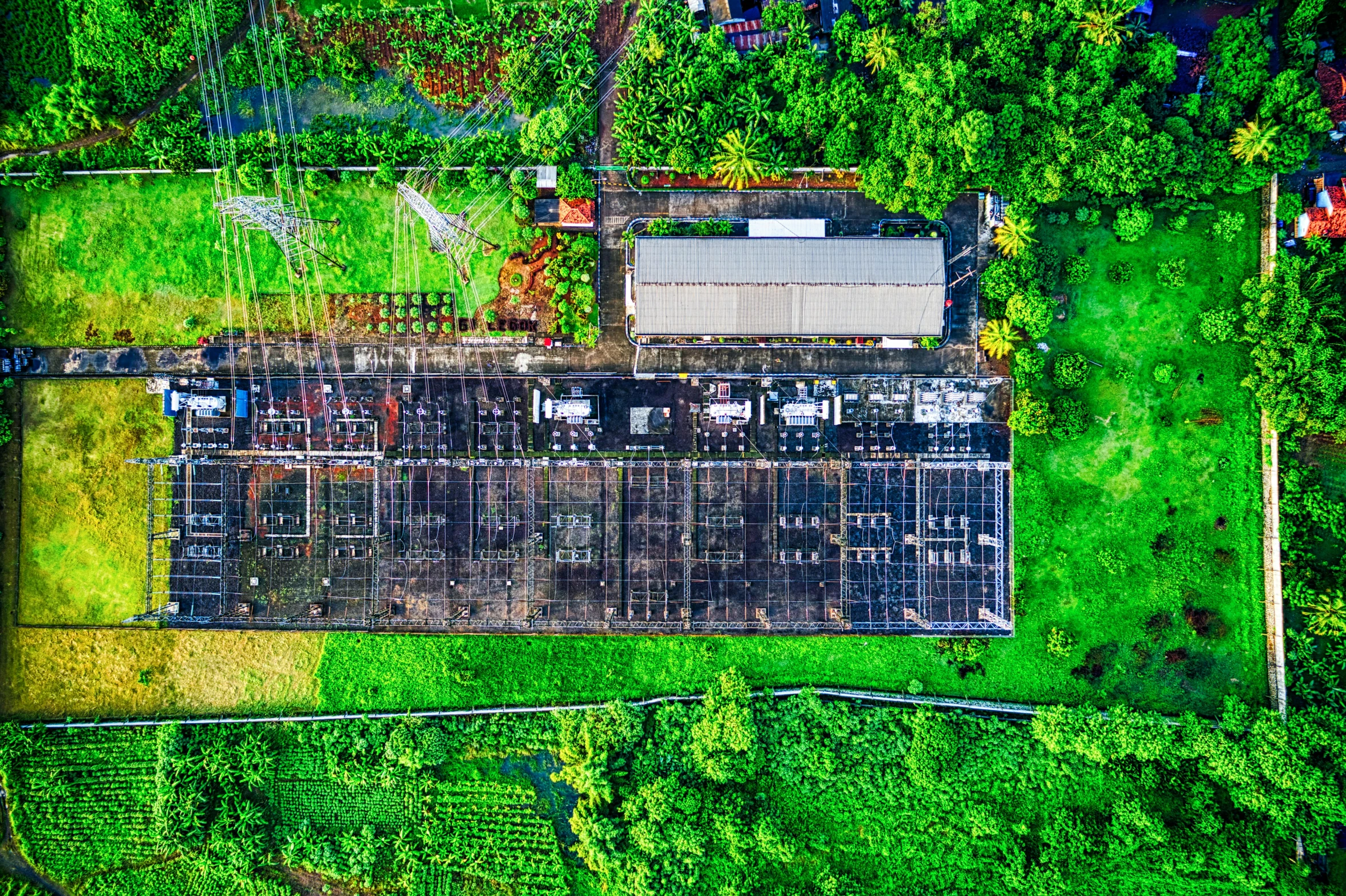 an aerial view of a building surrounded by trees, by Daniel Lieske, an abandoned rusted train, hydroponic farms, background image, solar