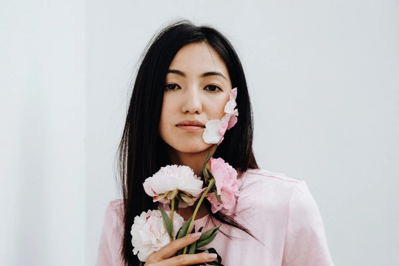 a woman holding a bunch of flowers in front of her face, an album cover, inspired by helen huang, trending on unsplash, hyperrealism, peony, portrait of mulan, pink, casually dressed