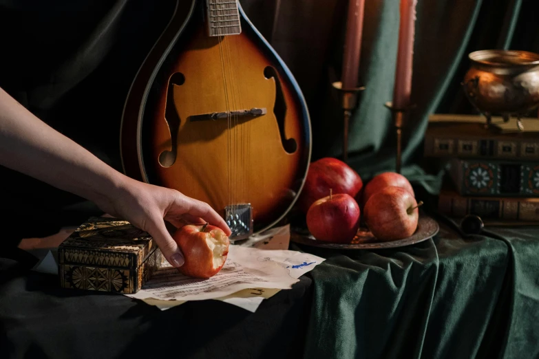 a mandolin sitting on top of a table next to a plate of fruit, an album cover, inspired by William Michael Harnett, pexels contest winner, mannerism, one holds apple in hand, performing, behind the scenes photo, alexandra fomina