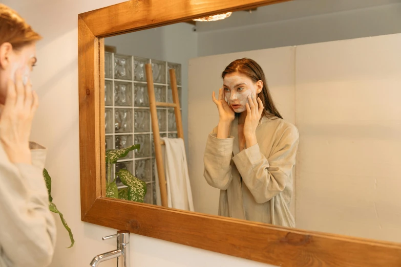 a woman shaving her face in front of a mirror, inspired by Elsa Bleda, trending on pexels, wearing wooden mask, reflected in giant mirror, on a wooden tray, ad image