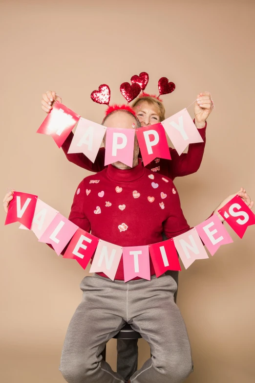 a little girl that is sitting on a chair, by Valentine Hugo, pexels contest winner, happening, red pennants, two men hugging, (pink colors), a still of a happy