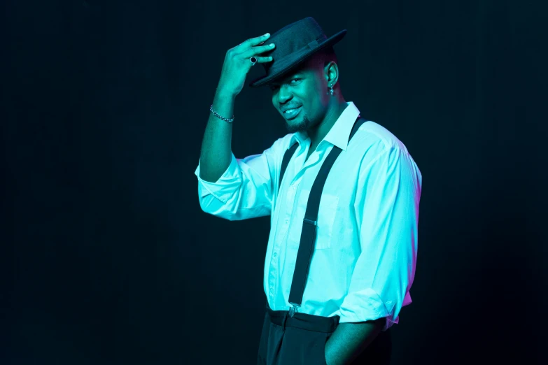 a man in a white shirt and black tie, an album cover, inspired by Theo Constanté, unsplash, happening, he is wearing a hat, teal studio backdrop, flashing lights, modeling shoot