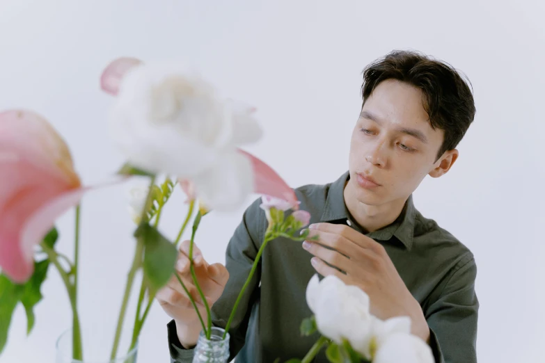 a man sitting at a table with a vase of flowers, performing a music video, siwoo kim, delicate features, youtube thumbnail