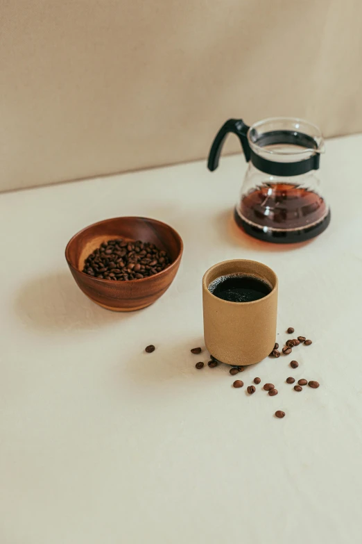 a cup of coffee next to a bowl of coffee beans, a still life, unsplash, product view, large tall, sustainable materials, pot