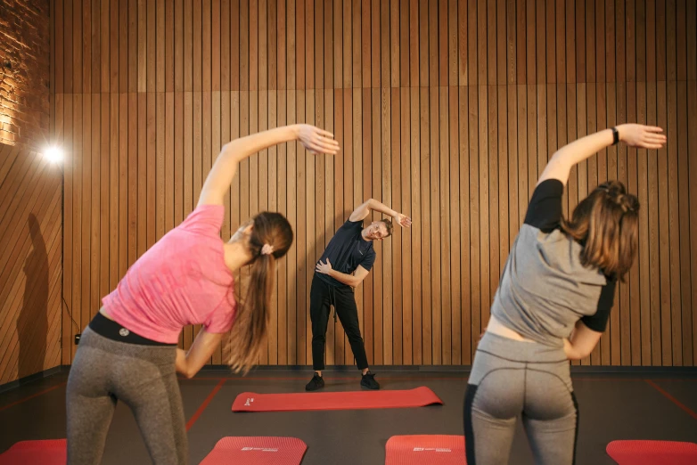 a group of women standing on top of a red mat, bend over posture, university, sweat, amanda lilleston