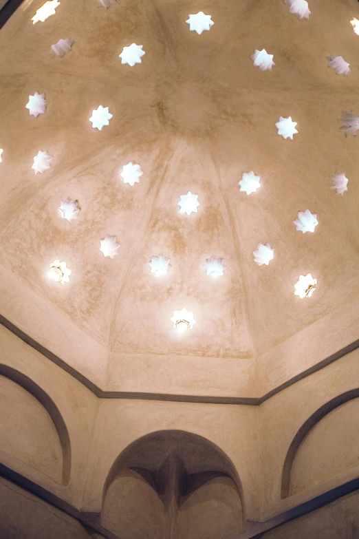 a close up of a dome in a building, inspired by Riad Beyrouti, light and space, 1996, vaulted ceiling, spot lights, petals