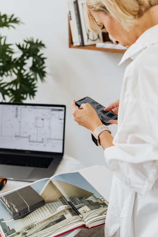 a woman sitting at a desk in front of a laptop, a computer rendering, trending on pexels, modernism, architectural plan, wearing a white button up shirt, holding controller, construction