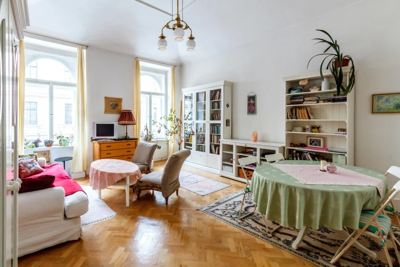 a living room filled with furniture and a dining table, by Konrad Witz, pexels contest winner, light and space, old apartment, pale yellow walls, a blond, small library