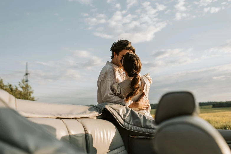 a woman sitting on top of a couch next to a dog, by Emma Andijewska, trending on unsplash, romanticism, on a boat on a lake, couple kissing, sitting in her car, soft top