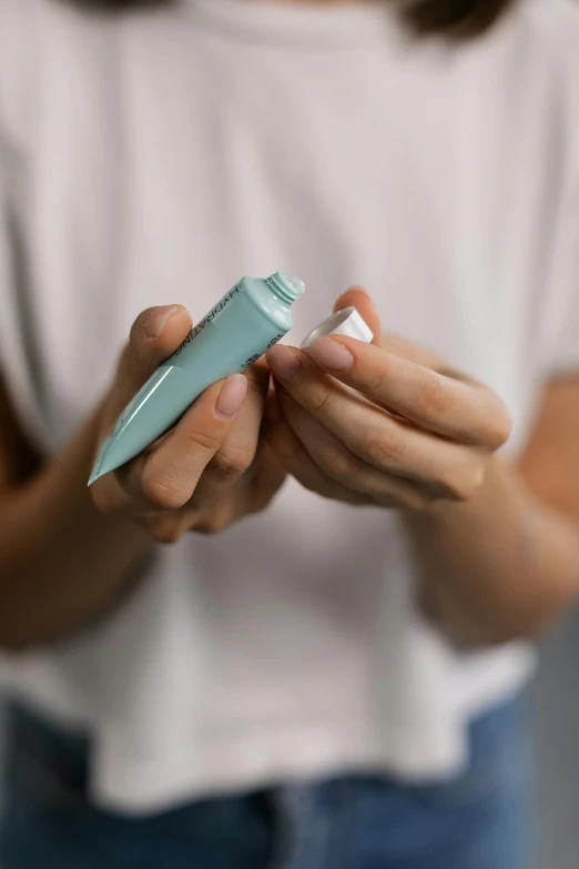 a close up of a person holding a cell phone, nasal strip, toothpaste refinery, detailed product image, eucalyptus