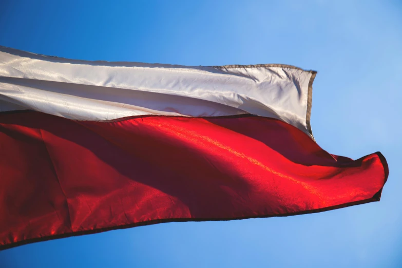 a red and white flag blowing in the wind, by Adam Marczyński, pexels contest winner, hurufiyya, tricolor background, polish, gradient brown to red, 15081959 21121991 01012000 4k