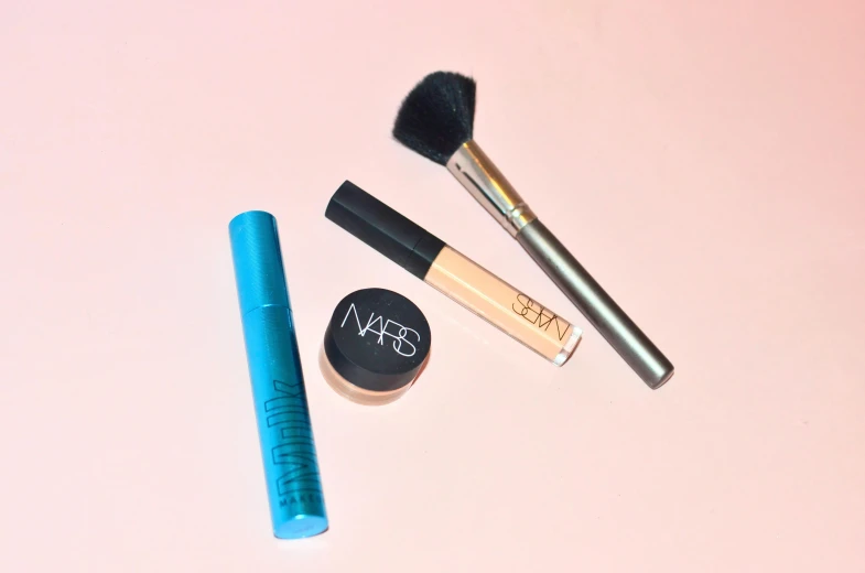 a couple of makeup brushes sitting on top of a table, blue lipstick, outlined, light pink lipstick, plain background