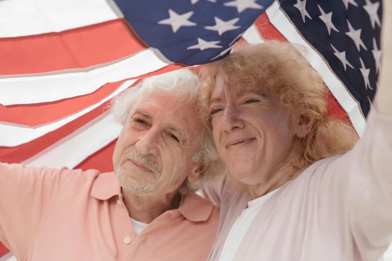 a man and a woman holding an american flag, a portrait, pexels, american romanticism, curly white hair, grandma, coloured, two frail