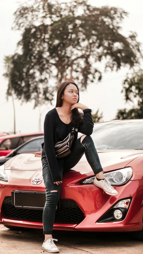 a woman sitting on the hood of a red sports car, by Basuki Abdullah, pexels contest winner, photorealism, 😭 🤮 💕 🎀, panoramic view of girl, square, gif