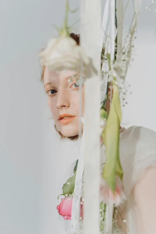 a woman that is standing in front of a mirror, inspired by Anna Füssli, trending on unsplash, renaissance, ribbons and flowers, showstudio, close up portrait photo, hanging from white web