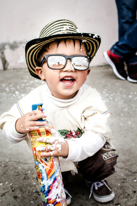 a little boy wearing a hat and glasses holding a skateboard, a picture, pexels contest winner, confetti, peruvian boy looking, square rimmed glasses, having a cool party