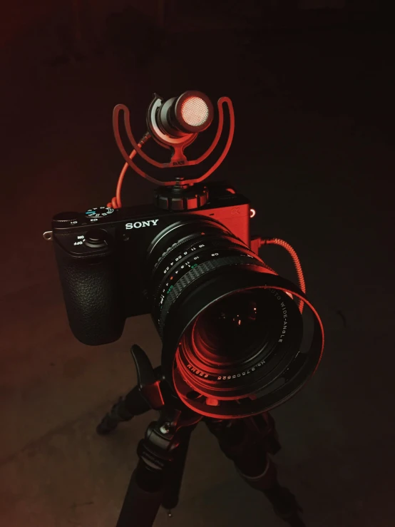 a close up of a camera on a tripod, by Adam Marczyński, unsplash contest winner, video art, volumetric lighting. red, front flash, sony a 7 r 3, instagram post