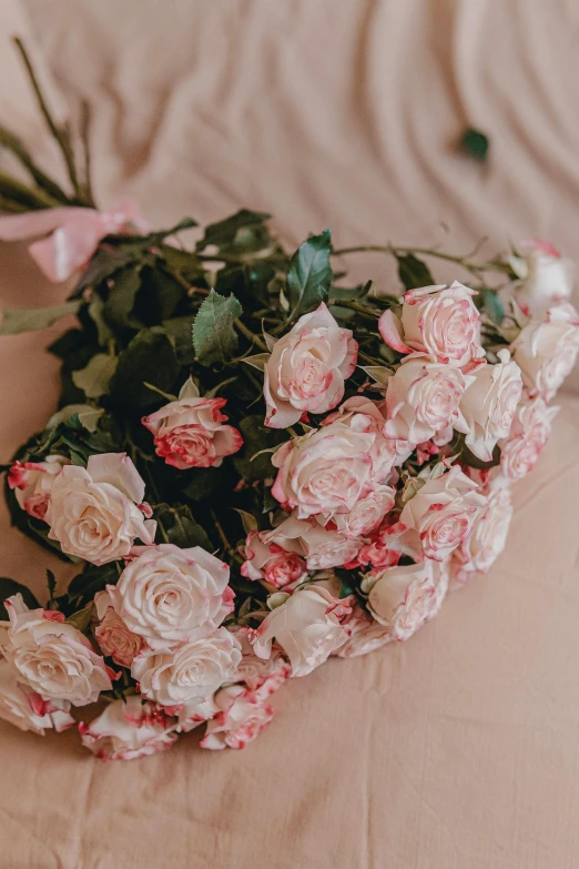 a bunch of flowers sitting on top of a bed, by Valentine Hugo, trending on unsplash, romanticism, pastel roses, slightly tanned, stunning details, long