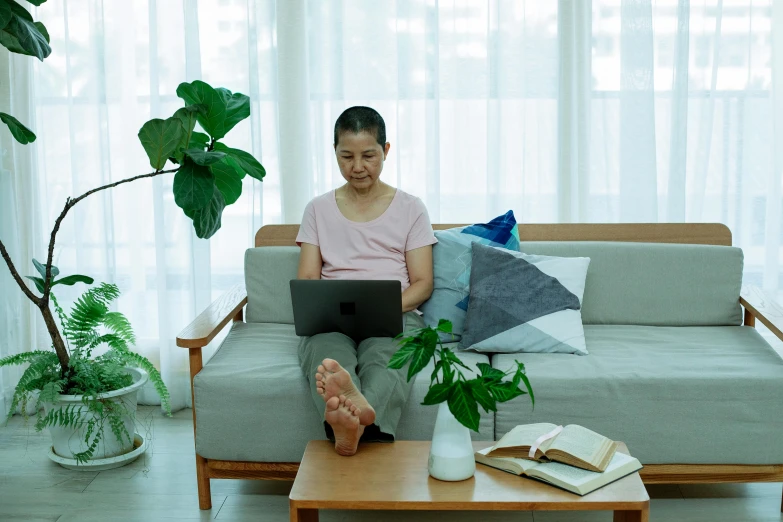 a woman sitting on a couch using a laptop, inspired by Ruth Jên, pexels contest winner, asian male, avatar image, home office, medium level shot