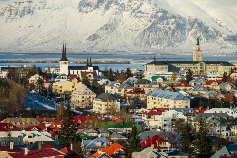 a view of a town with a mountain in the background, inspired by Júlíana Sveinsdóttir, pexels contest winner, square, reykjavik, black domes and spires, a colorful