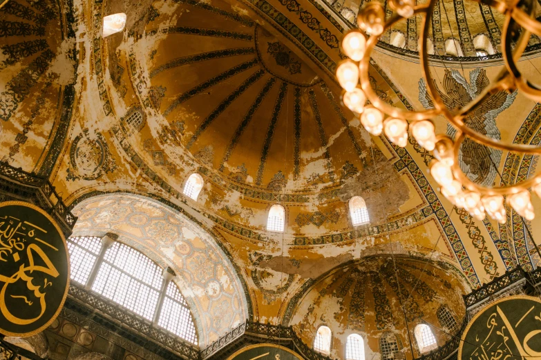 a chandelier hanging from the ceiling of a building, a mosaic, by Tobias Stimmer, unsplash contest winner, with great domes and arches, yellow windows and details, 2000s photo, marble and gold