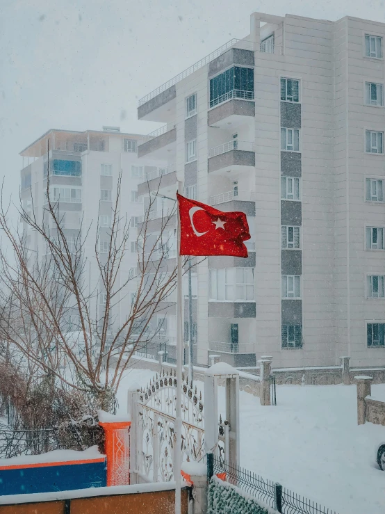 a red and white flag on a pole in the snow, a colorized photo, inspired by Elsa Bleda, pexels contest winner, hurufiyya, turkey, firing it into a building, ☁🌪🌙👩🏾, snapchat photo