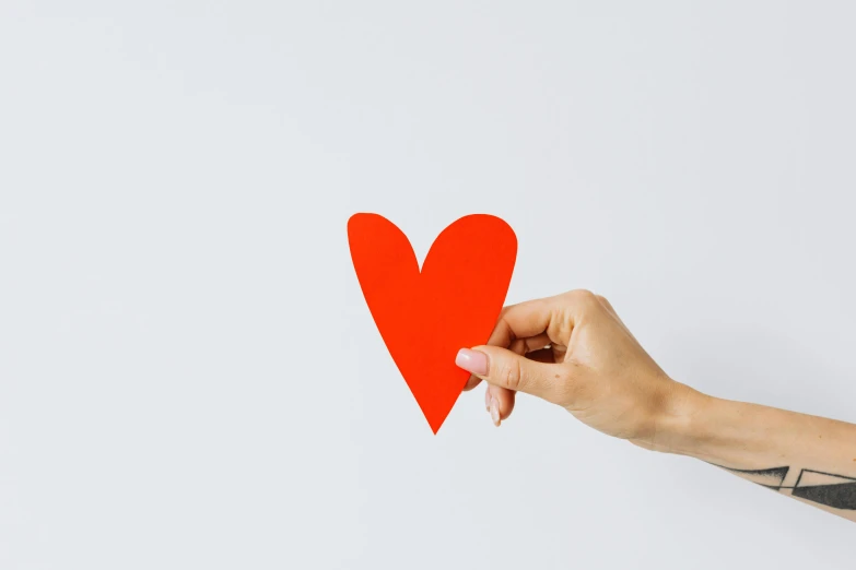 a person holding a red paper heart in their hand, by Gavin Hamilton, trending on pexels, visual art, on white paper, diecut, instagram post, magic heart