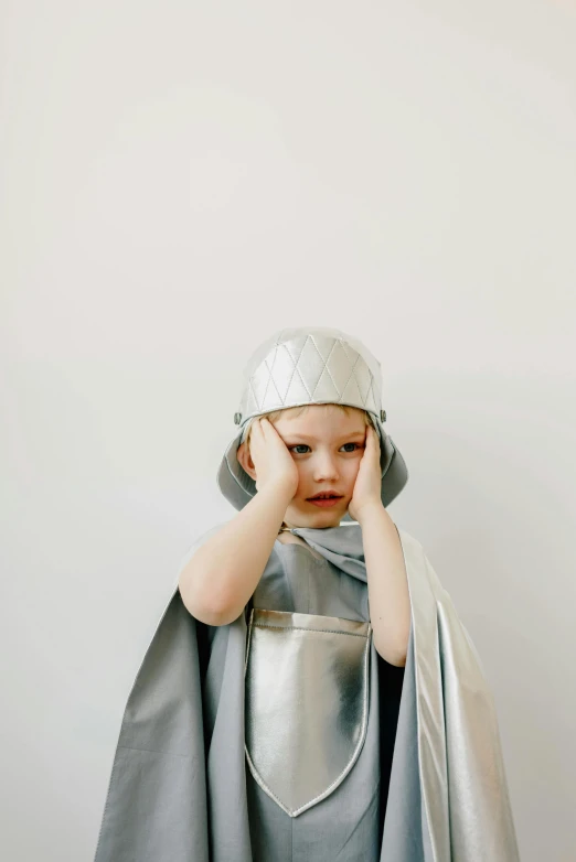 a little boy dressed up as a knight, an album cover, by Rebecca Horn, pexels, hypermodernism, grey aliens, worried, silver，ivory, ignant