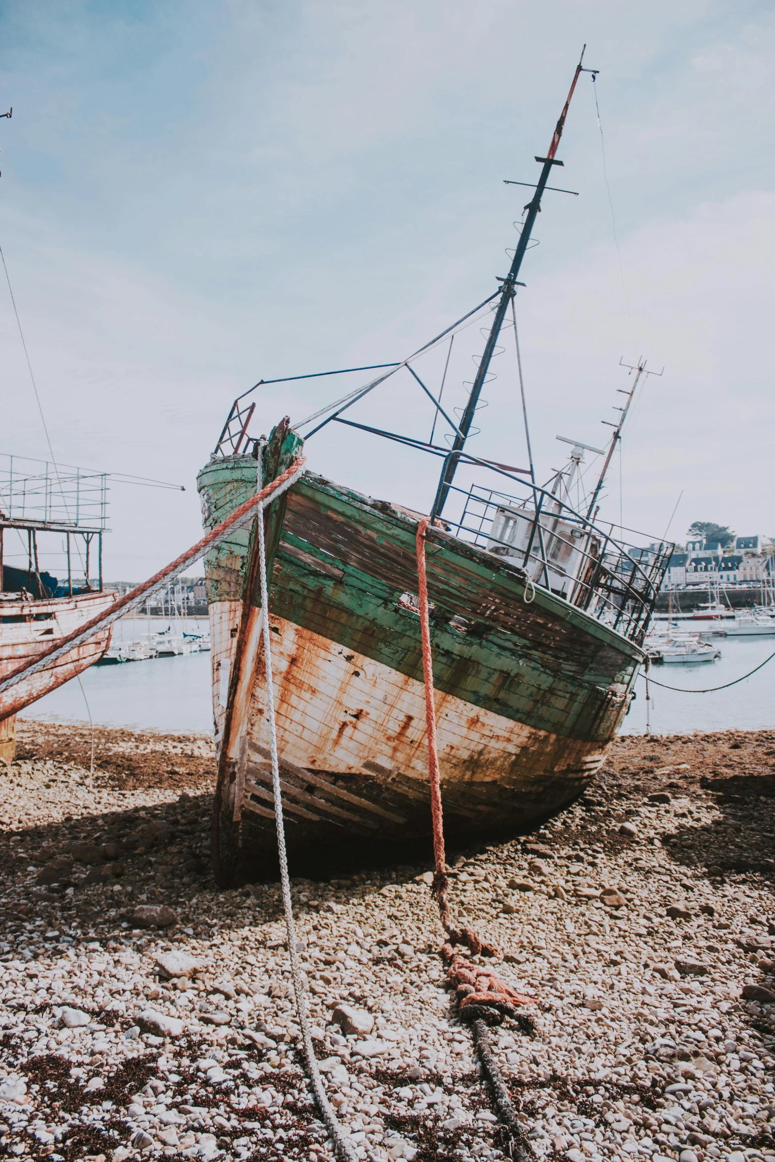 a boat sitting on top of a beach next to a body of water, pexels contest winner, auto-destructive art, photo of poor condition, shipyard, lumpy skin, cyprus