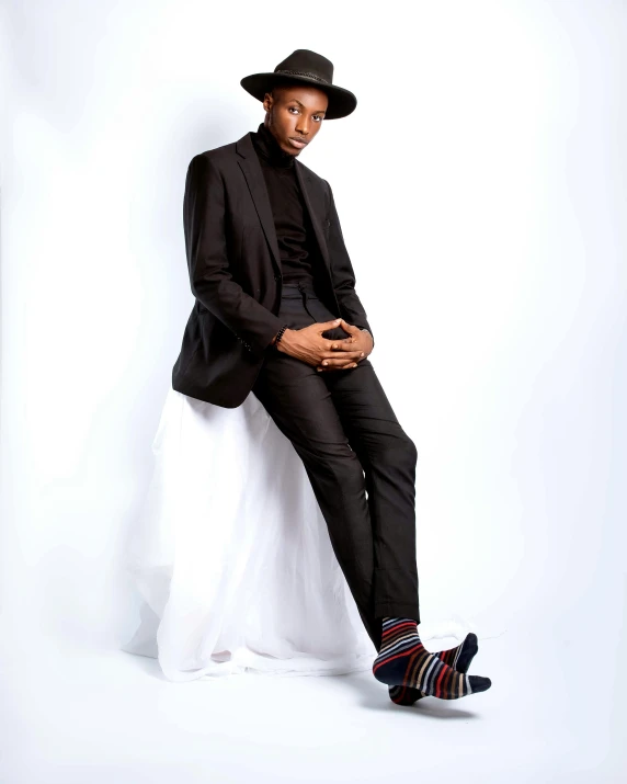 a man in a suit and hat sitting on a chair, an album cover, by Chinwe Chukwuogo-Roy, non binary model, full body profile pose, black loafers, profile image