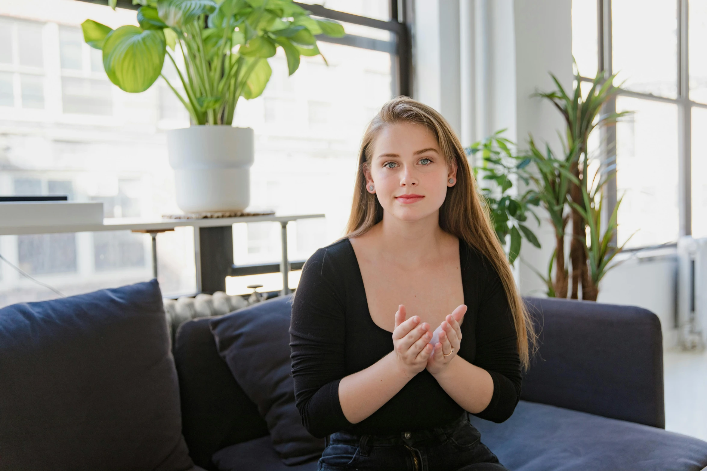 a woman sitting on a couch in a living room, a portrait, pexels contest winner, sydney sweeney, anjali mudra, avatar image, sitting in office