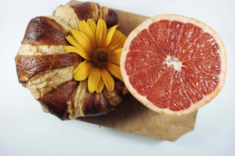 a grapefruit and a croissant on a piece of paper, unsplash, made of flowers and fruit, grain”, award-winning crisp details”, 🦩🪐🐞👩🏻🦳