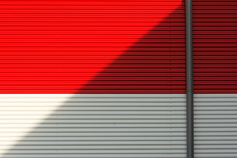 a fire hydrant in front of a red and white wall, a digital rendering, inspired by Andreas Gursky, pexels contest winner, postminimalism, metal cladding wall, directional sunlight skewed shot, in front of a garage, indonesia
