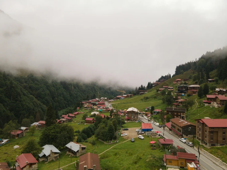 an aerial view of a small town in the mountains, a picture, by Muggur, misty and wet, vacation photo