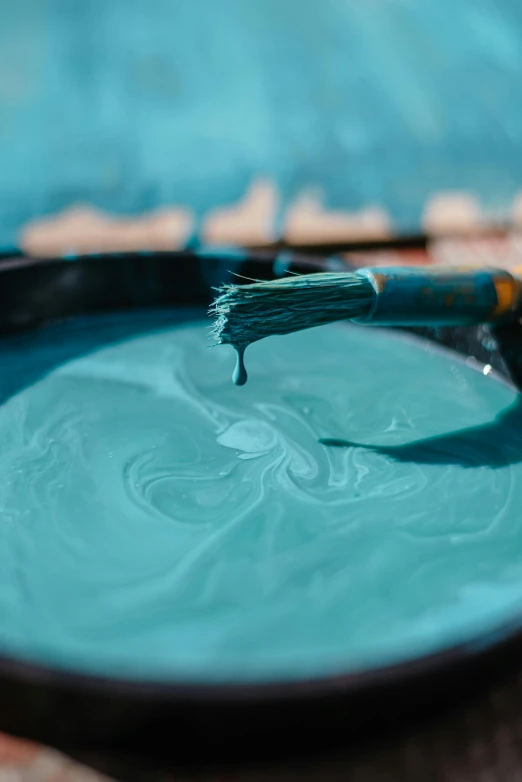 a close up of a bowl of paint with a brush, inspired by Hu Zao, trending on unsplash, process art, turquoise, vinyl material, ilustration, pouring