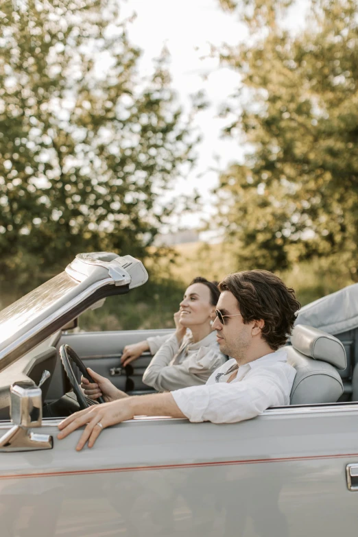 a man and a woman sitting in a convertible car, trending on unsplash, romanticism, timothee chalamet, profile image, top down angle, idyllic